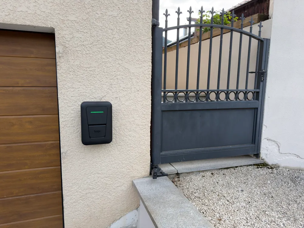 Borne de recharge murale posée à côté d'un portail
